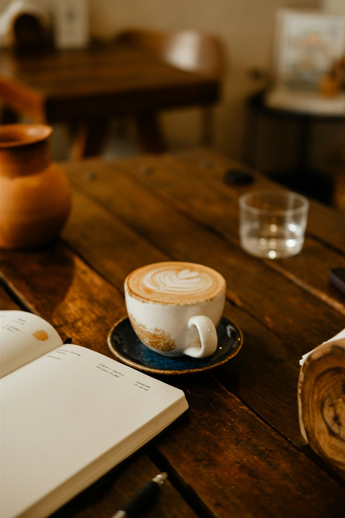 Café y cuaderno sobre una mesa de madera