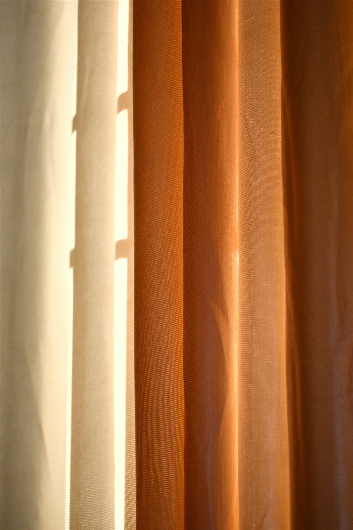Cortinas de lino crema y terracota con luz cálida